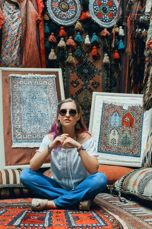Couple in love walks and hugs at the Eastern carpet market. A man and a woman choose a Turkish carpetの写真素材