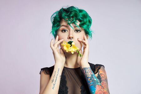 Woman with creative green coloring hair and makeup, toxic strands of hair. Bright color curly hair...