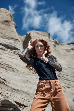 Beautiful woman with long red hair posing in nature. Beautiful natural makeupの写真素材