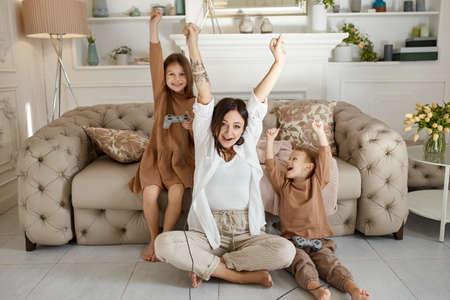 Family prepares lunch in the kitchen. Mom teaches her daughter and son to prepare a Salad of fresh vegetables. Healthy natural food, vitamins for childrenの写真素材