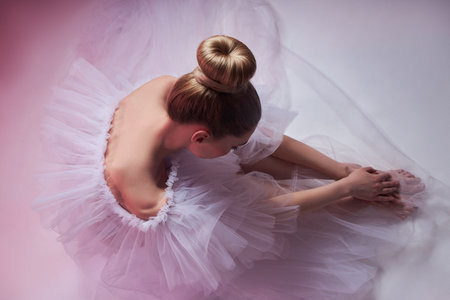 Beauty Woman bright red makeup sits on the floor. Art Girl in a transparent light dress on a pink background. Professional bright makeup womanの写真素材