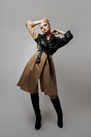 Beauty fashion young woman in trench coat, professional face makeup girl. Portrait of woman on white background. Spring clothing in rainy weatherの写真素材