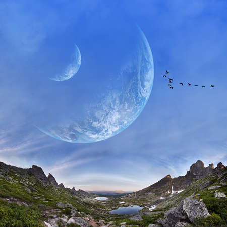 Panoramic mountains and two planets in sky. Fantastic world, birds flying against the background...
