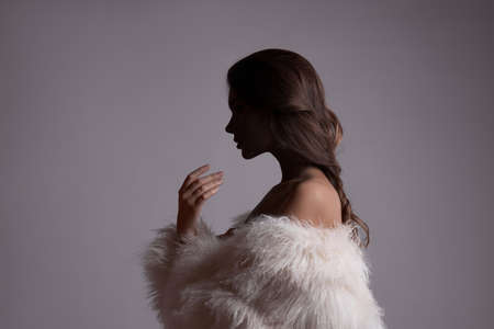 Beautiful young woman with gift in hands. Woman in a blue dress on a white background hold red gift boxes. holiday shoppingの写真素材