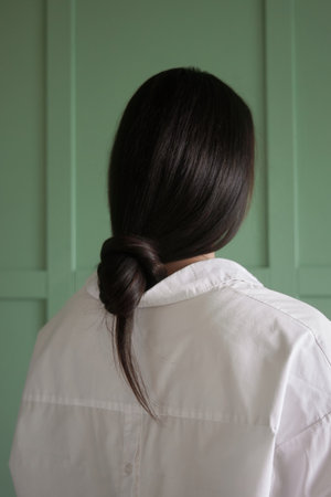 Happy Young Adult Woman with Long black Hair Standing Indoors in Casual Clothingの写真素材