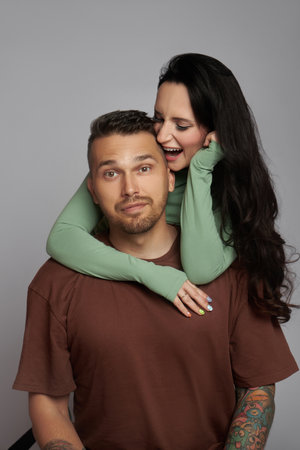 Woman hugs man with tattoos, happy couple, youth and passion. Love and relationships, tenderness and happinessの素材