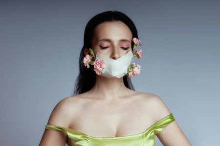 Woman with mask on face from which flowers grow, beauty portrait spring allergy, respiratory protectionの写真素材