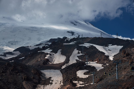 Nestled in Russia Caucasus, majestic mountain landscape captivates with its snow covered peaks,...