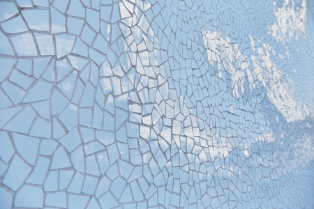 Detailed blue mosaic tile wall with sunlight reflecting off its surfaceの写真素材