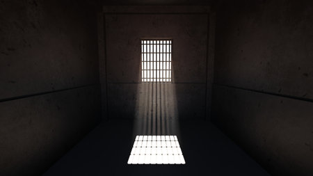 Solitary ray of light illuminates the dusty floor of a prison cell, streaming in through a barred...