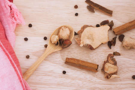 Spices on a cutting board on wooden tableの写真素材