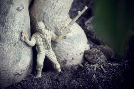 miniature toy soldiers under big tree are arrayed on the groundの写真素材