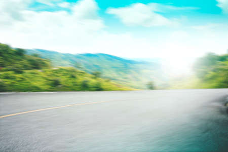 motion asphalt forest road and perfect green field