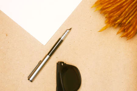 Blank sheet of paper and pen, sunglasses on wooden