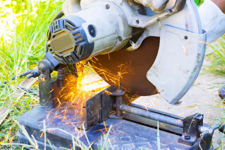 Worker cutting metal with many sharp sparks