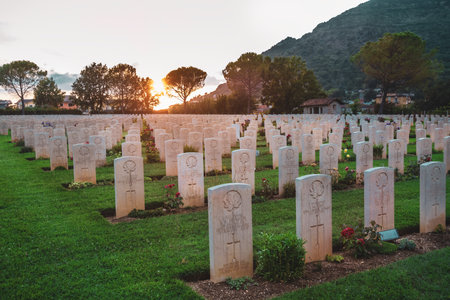 Cassino / Italy - August 17, 2019: War memorial Canadian tombstone with epitaph. Commonwealth Cemetery of Cassino in Italy of the Second World War. Canada heroes, leaf symbol. Sunset.のeditorial素材