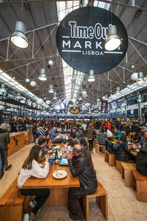 Lisbon, Portugal. January 4, 2019: Time Out Market Lisboa is a food hall located in the Mercado da Ribeira at Cais do Sodre in Lisbon, Portugal. Crowd of people eating.