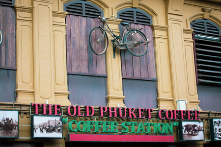 Phuket, Thailand. August 3, 2019: Facade of an ancient palace in the historical center of Phuket in Thailand. Sign of a coffee station "the old Phuket coffee", a bicycle hangs on the facade.のeditorial素材