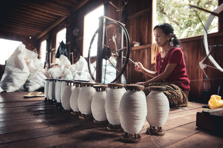 Inle, Myanmar. July 30, 2019: Woman who works by hand. Lotus, silk and cotton loom inside a...
