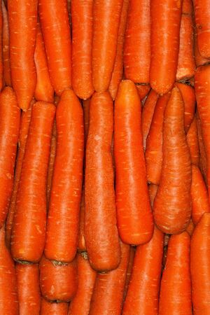 Carrots background pile. Ordered vertically. Healthy food.