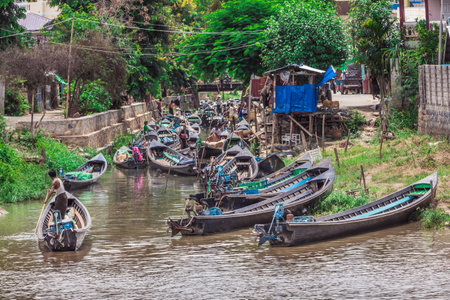 Canton de Nyaungshwe, Shan, Myanmar. July 31, 2019: Inle Boat Station in Inle Nyaung Shwe Canal in Burma. A series of wooden fishing boats along the river generated by Inle Lake.のeditorial素材