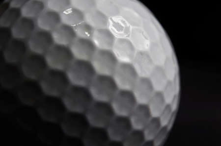 Close up of a white Golf ball on a black backgroundの写真素材