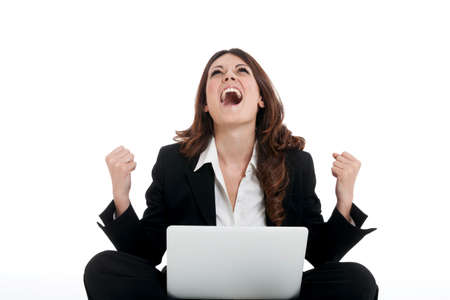 Excited woman with arms up winning online - isolated over whiteの写真素材