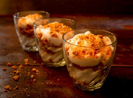 Creamy tiramisu dessert in glass on wooden table.の写真素材