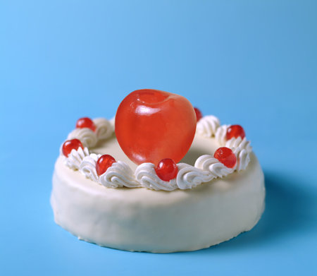 Birthday cake with red heart on blue background, close-up