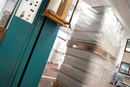 Blurred image of a forklift moving boxes in a warehouse.