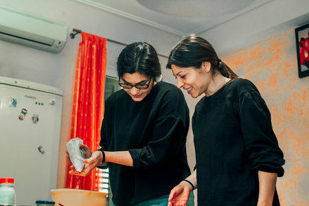 happy women make cookies together - concept of family cooking with smiles and happiness - photo session in the kitchen, people making the dough, people lifestyleの写真素材