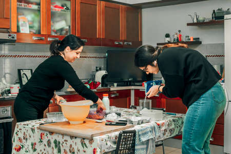 happy women make cookies together - concept of family cooking with smiles and happiness - photo...