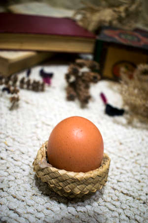 Easter egg in the close-up, dry flowers and petals, wooden box and books on white backgroundの写真素材