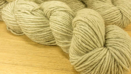 Colored wool balls with needles on a wooden tableの写真素材