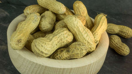 Dry peanuts in a wooden bowlの写真素材