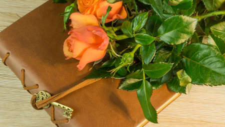 A book with key and a rose on a wooden tableの写真素材