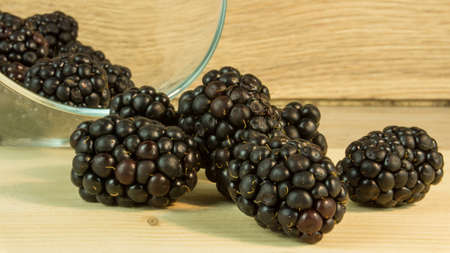 Blackberries in a glass on a wooden tableの写真素材