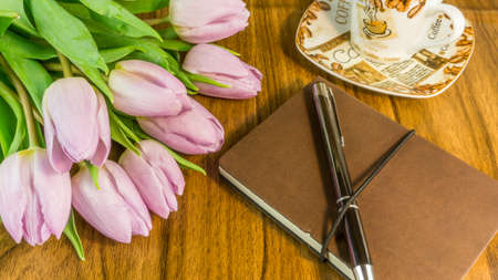 Notepad with ballpoint pen, coffee cup and flowersの写真素材