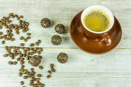 Cup of coffee with beans on a rustic wooden tableの写真素材