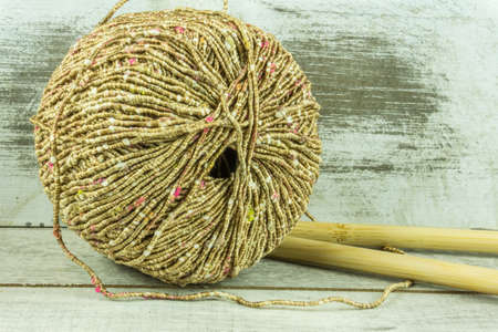 Colored wool ball with needles on a rustic wooden tableの写真素材