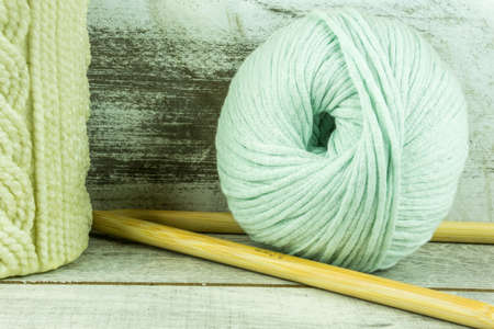 Colored wool ball with needles and a candle with knitted patternの写真素材