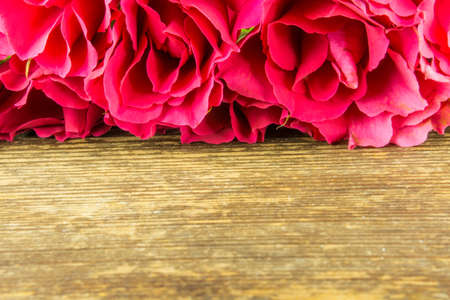 Red roses on a rustic wooden tableの写真素材