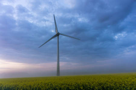 wind wheels at sunrise and fog with dark clouds