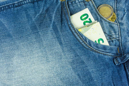 Jeans in blue with money in pocketの写真素材