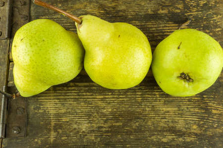 Green pears on a rustic wooden tableの写真素材