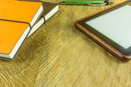 Notebooks in different colors with one ebook readerの写真素材