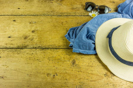 Straw hat, sunglasses and other accessories for summer on a wooden tableの写真素材