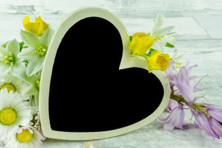 A heart with summer flowers on a wooden backgroundの写真素材