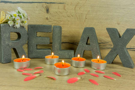 Rustic background of wood with candles and letters RELAXの写真素材