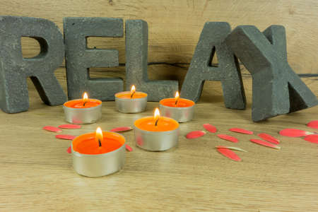 Rustic background of wood with candles and letters RELAXの写真素材
